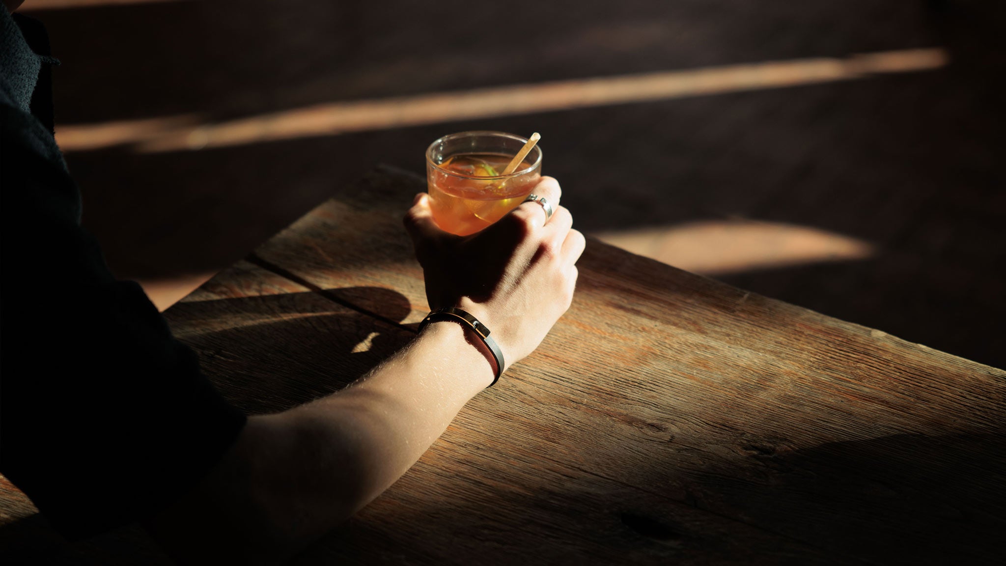 Bracelet U-TURN.9 en cuir noir porté par un homme, photographie lifestyle horizontale en lumière naturelle et chaude.